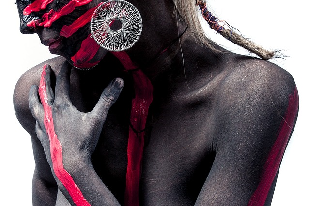 Žena s výrazne pomaľovaným telom s výraznými striebornými náušnicami